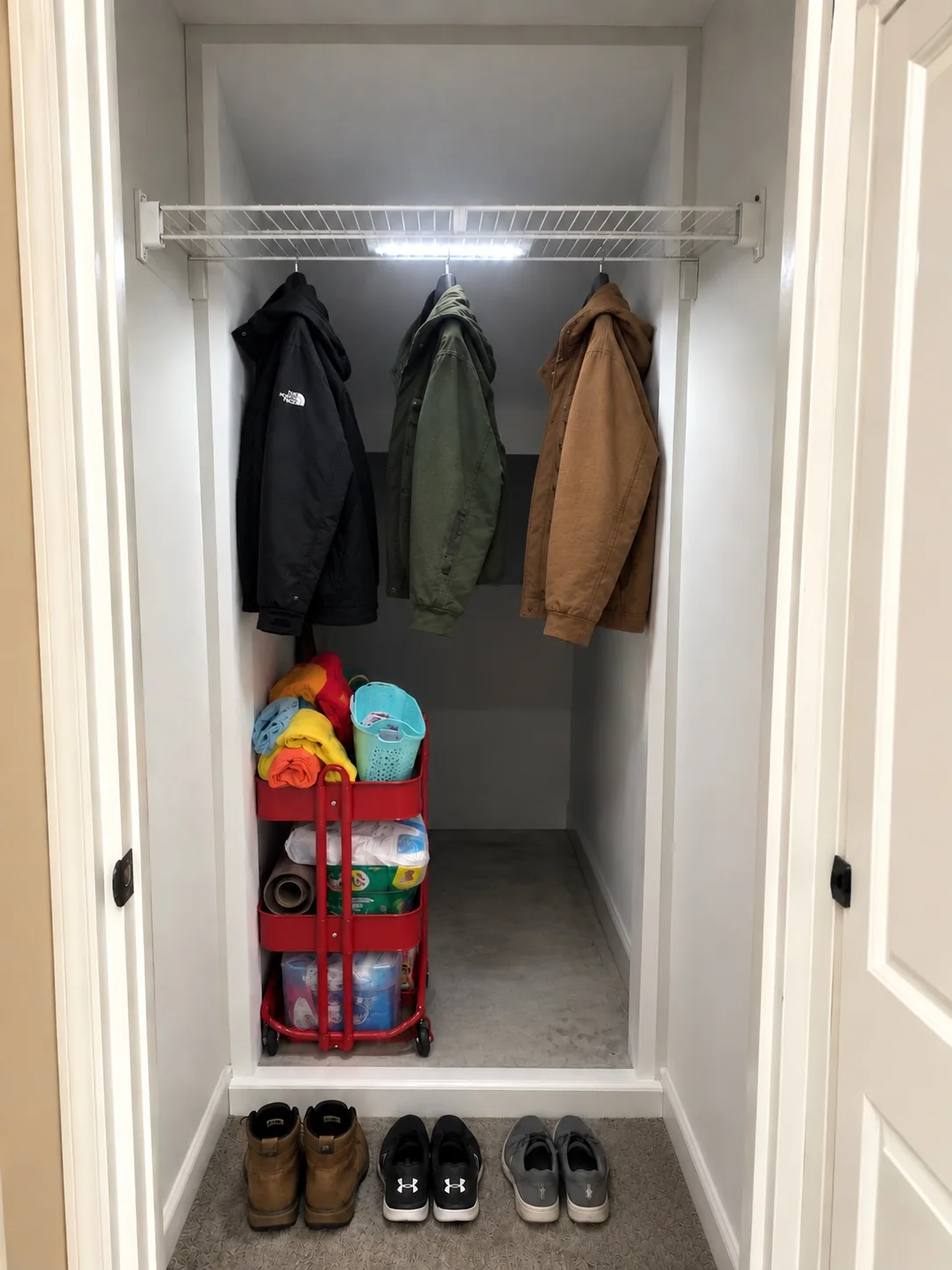 Expanded under-stair closet with shelf, hanging coats, and organized storage